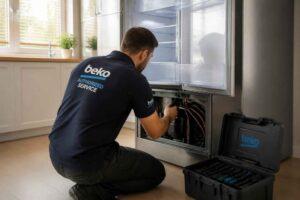 Technik Beko naprawia lodówkę, korzystając z narzędzi z otwartej walizki serwisowej